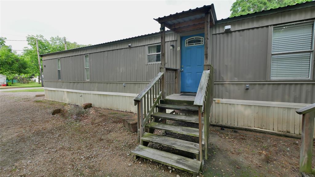 a view of a small house with wooden fence