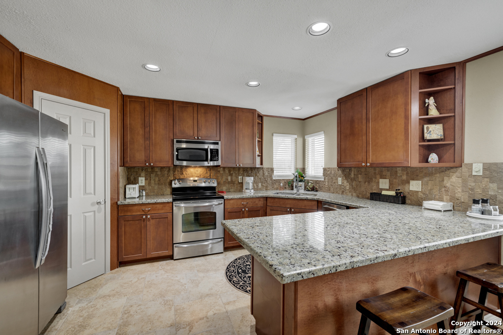 a kitchen with stainless steel appliances granite countertop a sink refrigerator and microwave