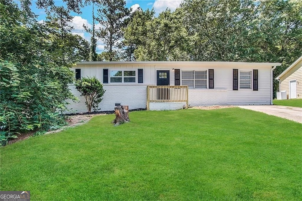 a front view of a house with a yard and trees