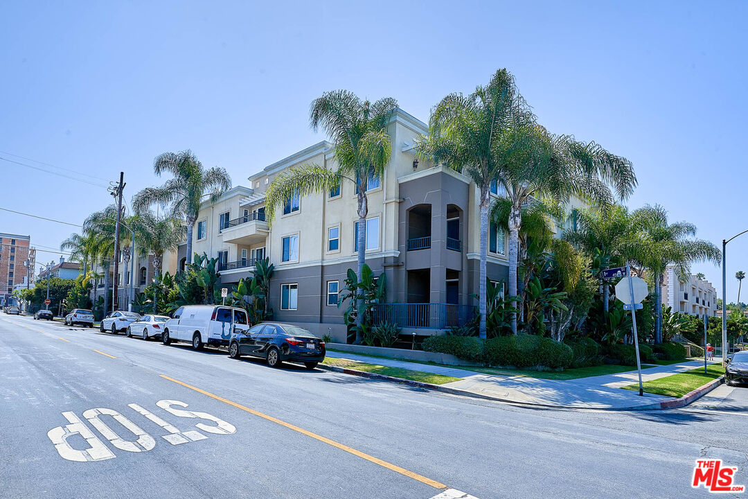 a front view of a building with palm trees