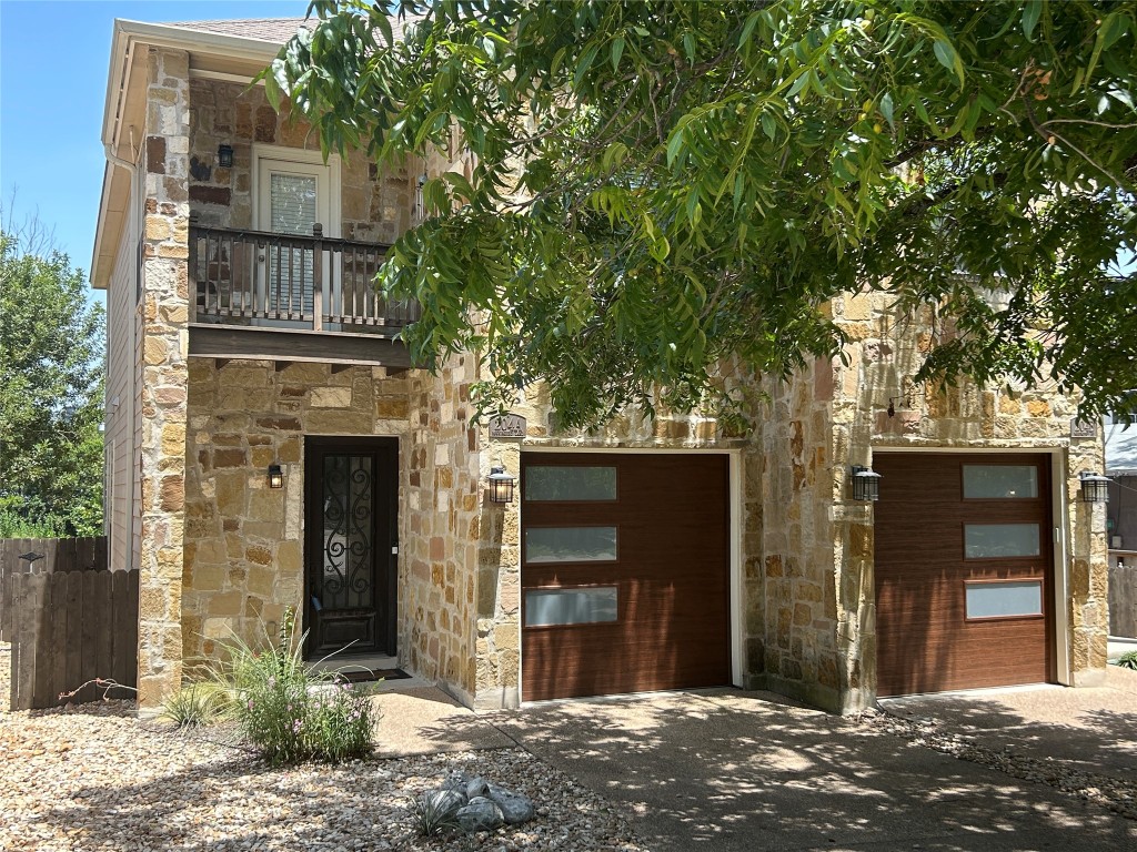 a front view of a house with a tree