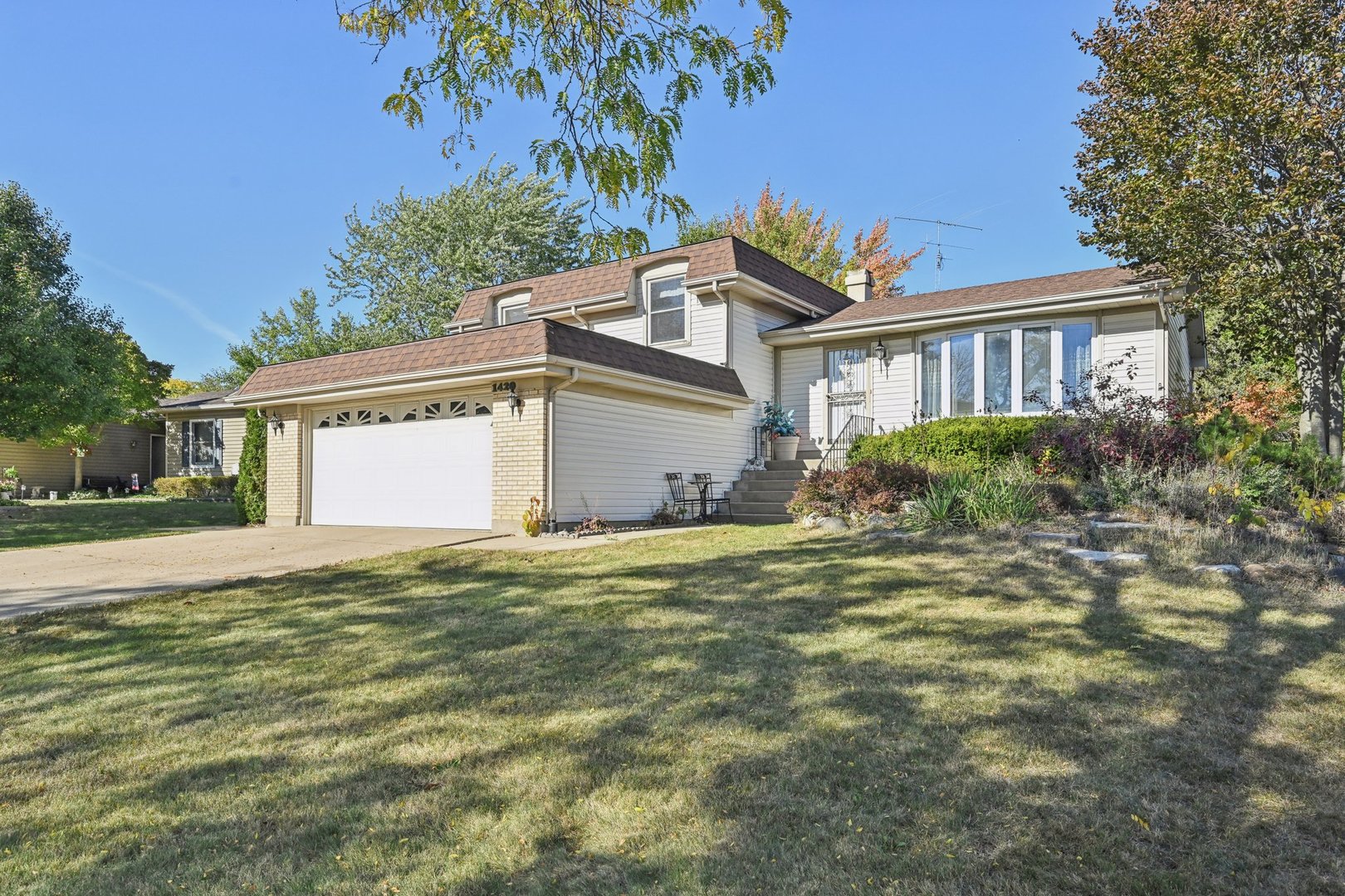 a front view of a house with a garden