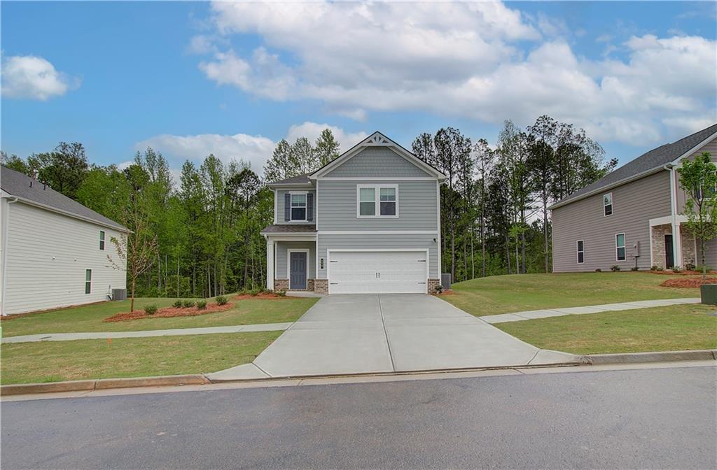 a front view of a house with a yard and trees