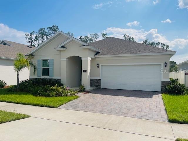 a front view of a house with a yard and a garage