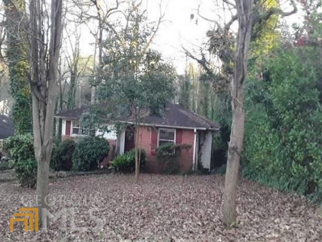 a view of a house with a yard and large trees