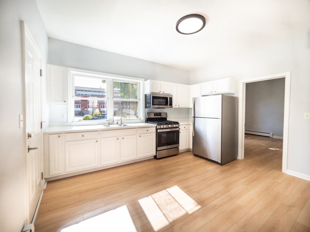 a kitchen with refrigerator cabinets and wooden floor