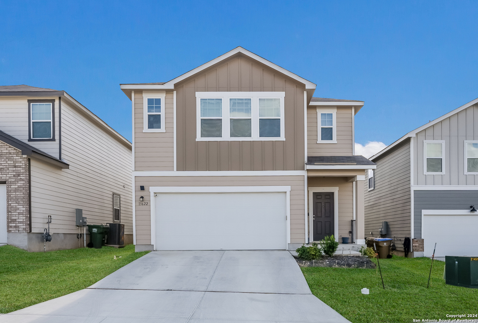 a front view of a house with a yard and garage