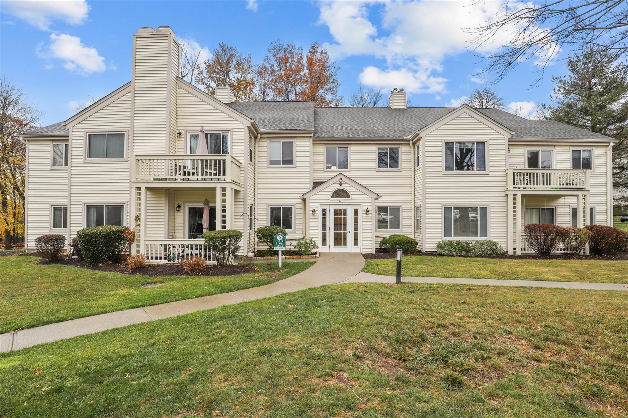 Townhome / multi-family property featuring a front lawn, french doors, and a balcony