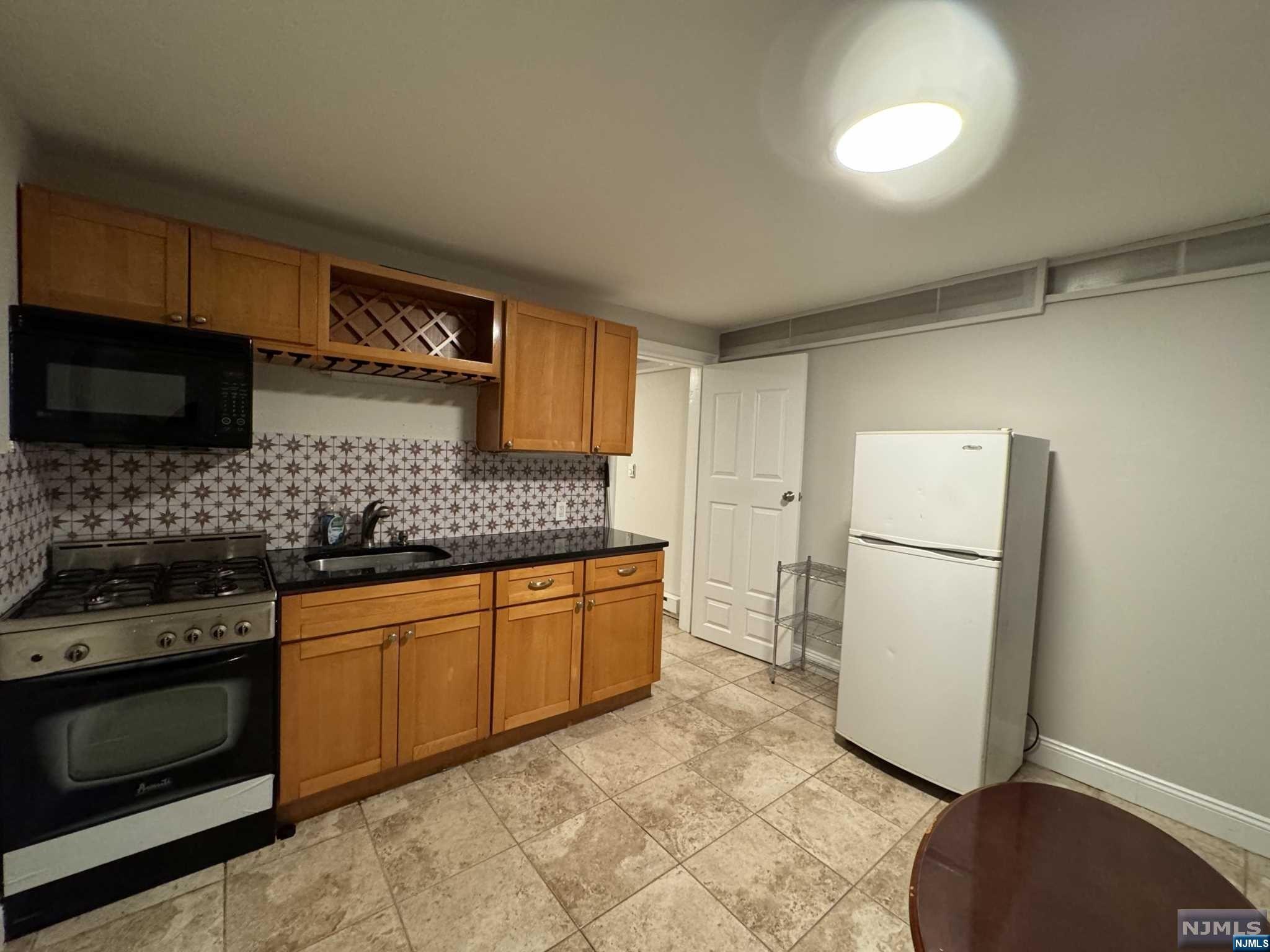 a kitchen with stainless steel appliances granite countertop a refrigerator sink and stove