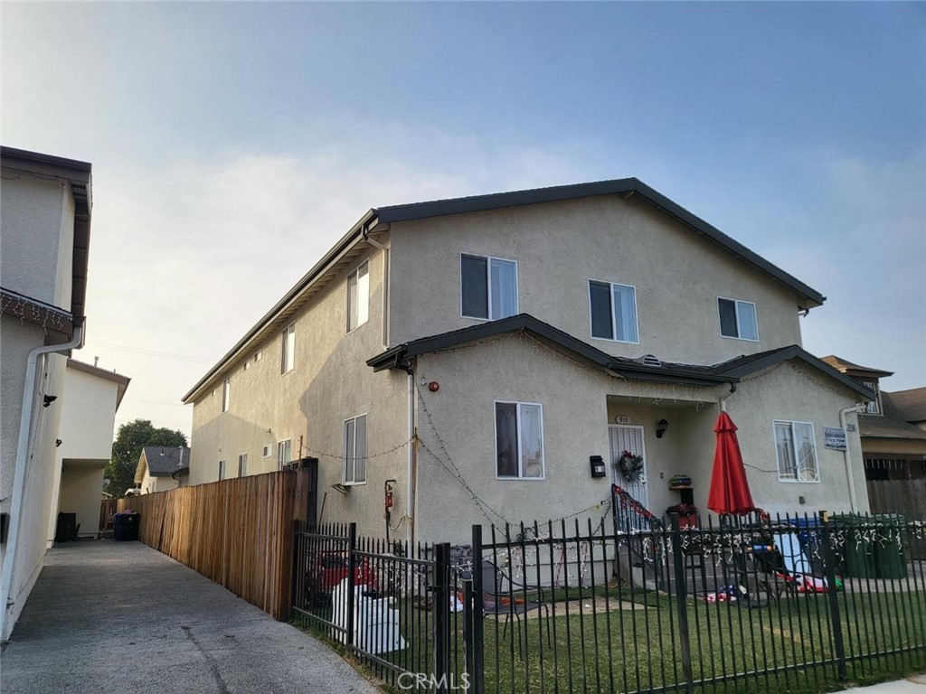 a view of a house with wooden fence and two windows