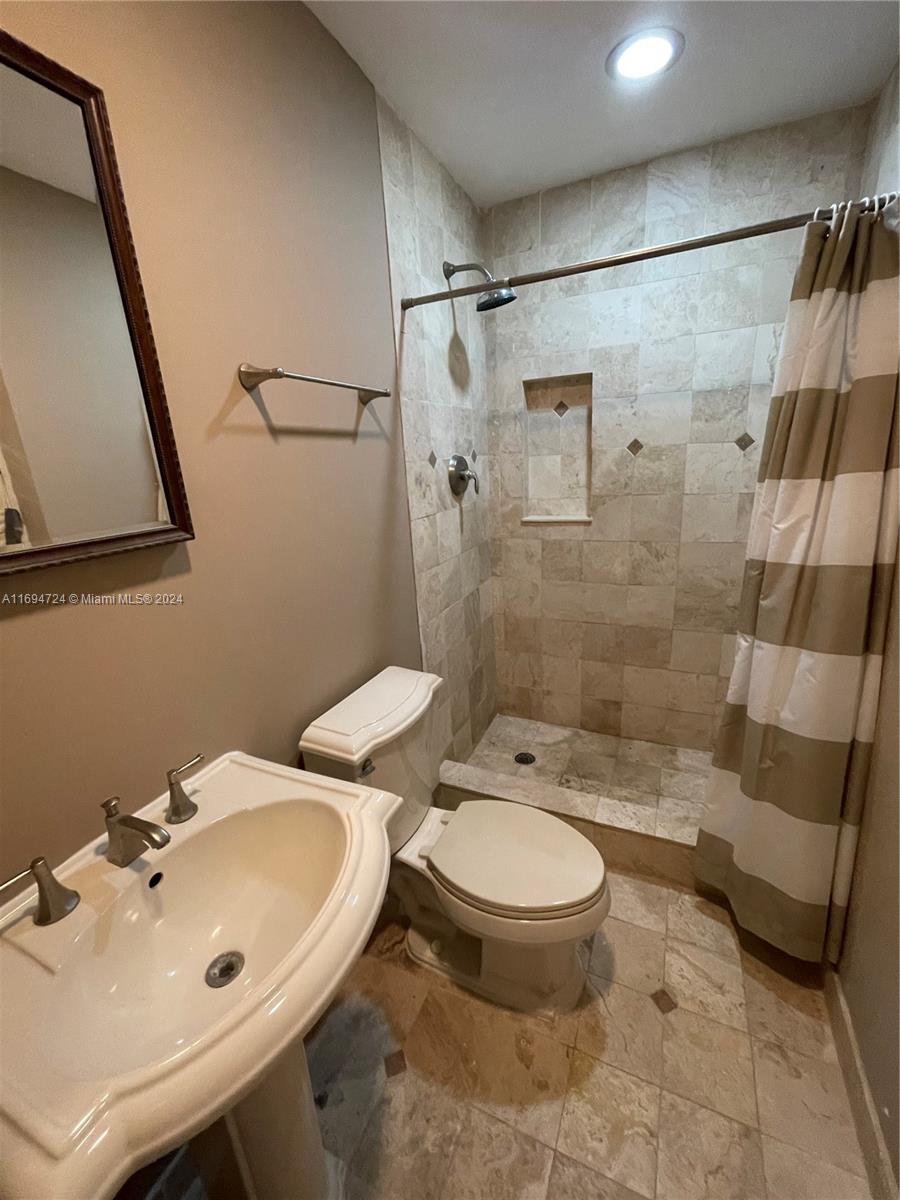 a bathroom with a sink toilet and shower