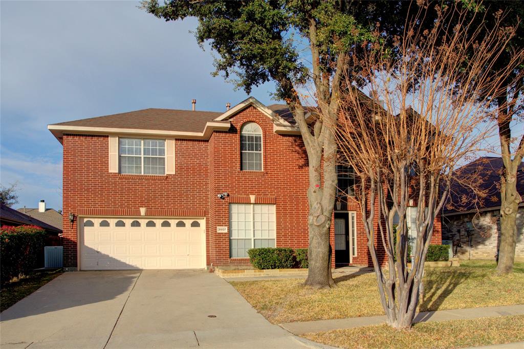 View of property featuring a garage and a front yard