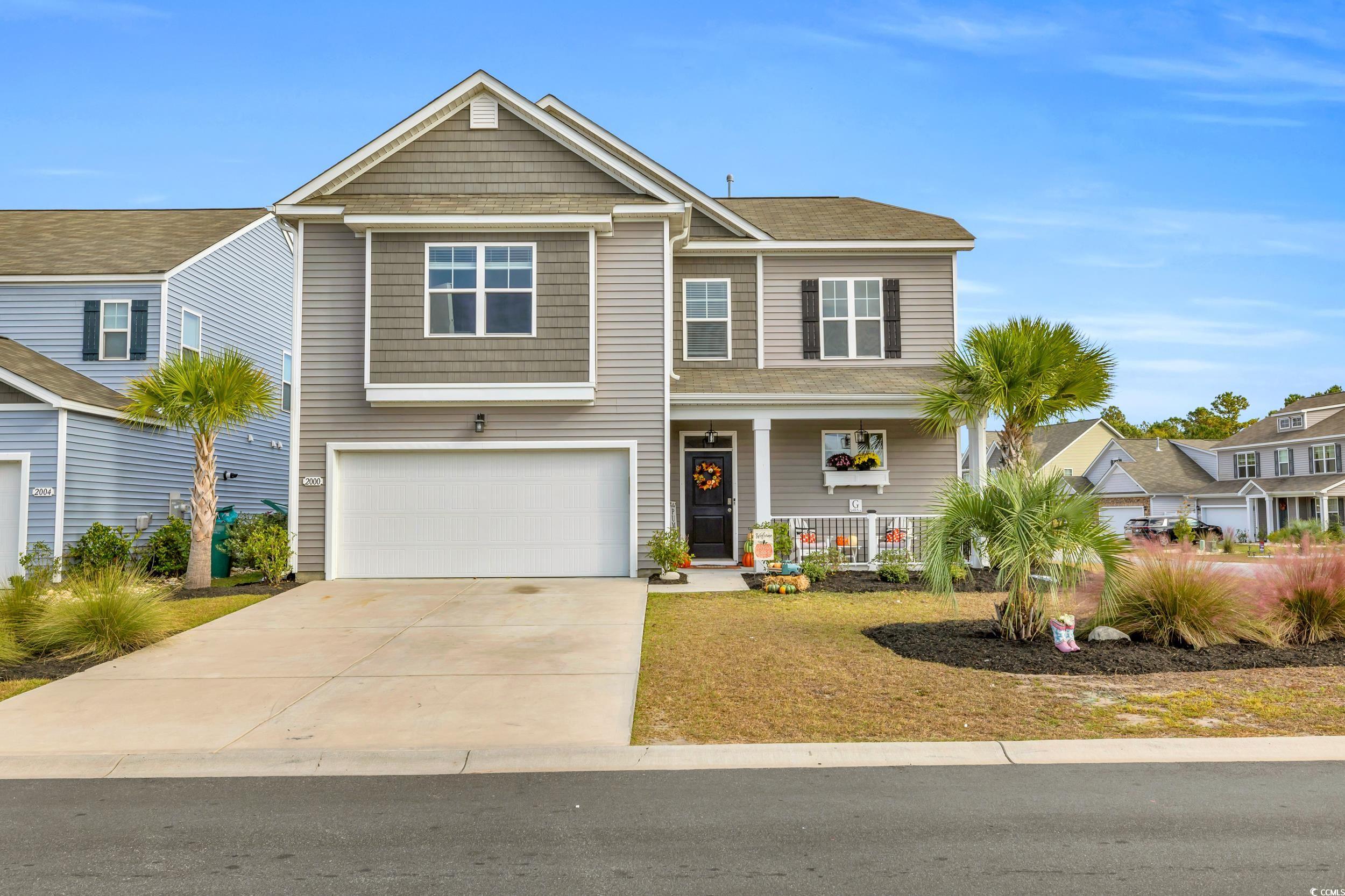 View of front of house with a garage and a porch