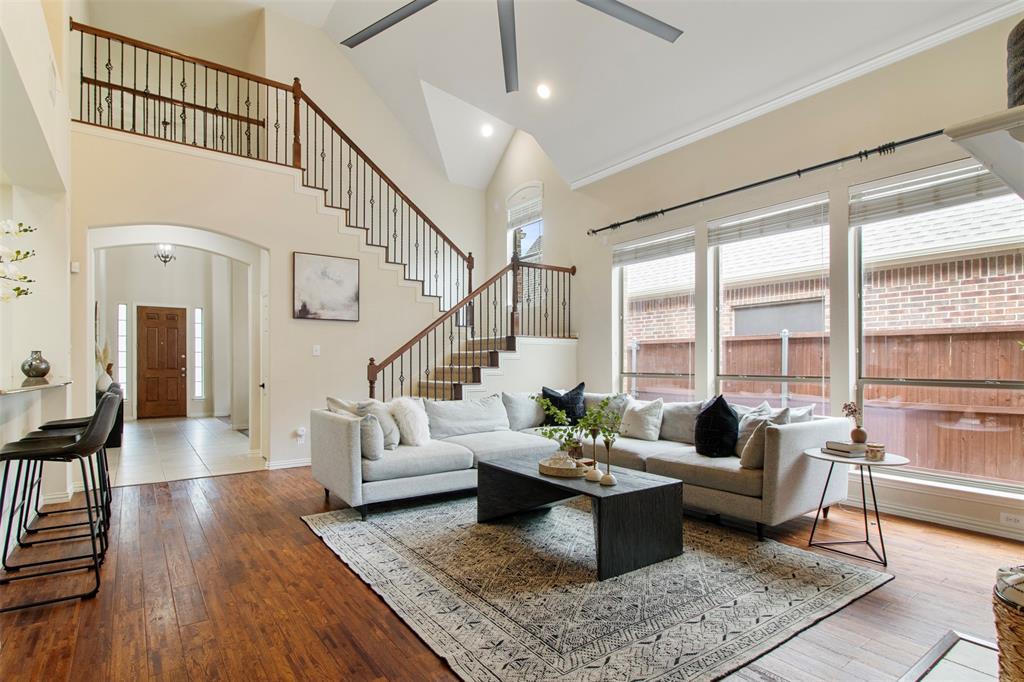 a living room with furniture wooden floor dining table and a large window