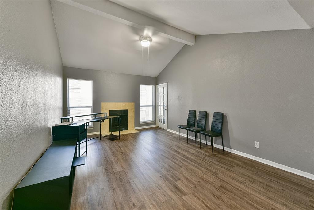 an empty room with furniture a fireplace and wooden floor