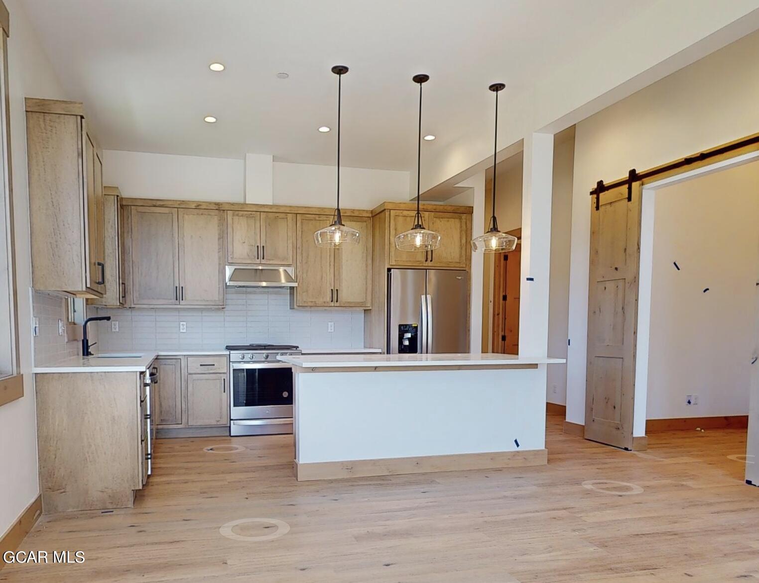 a view of a kitchen with a sink stainless steel appliances and cabinets