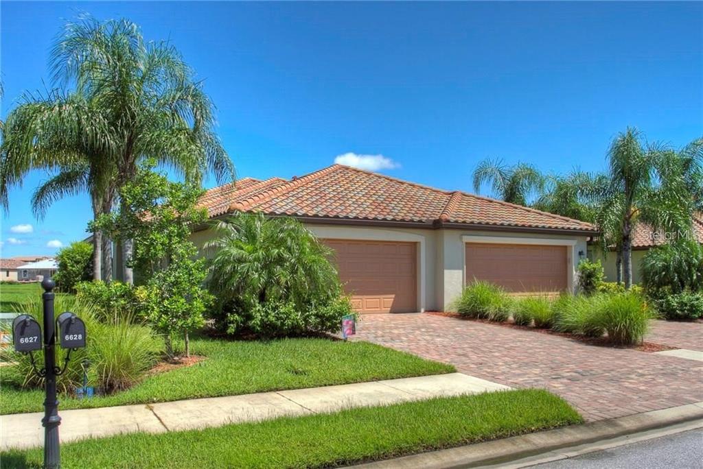 a front view of a house with a yard and potted plants