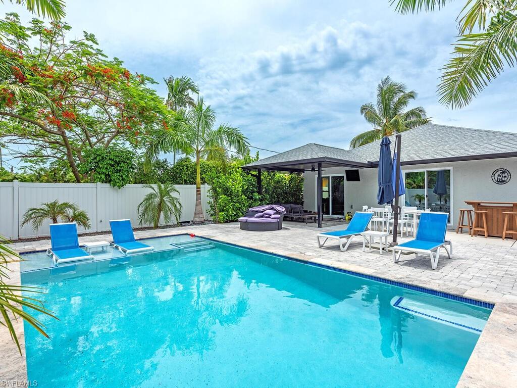 a view of a house with swimming pool and sitting area