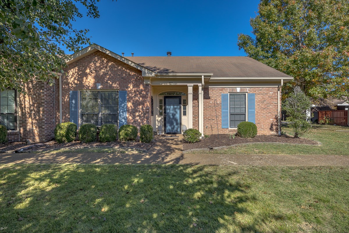 a view of a house with a yard and tree s