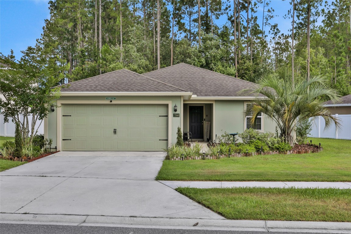 a front view of a house with a garden and yard