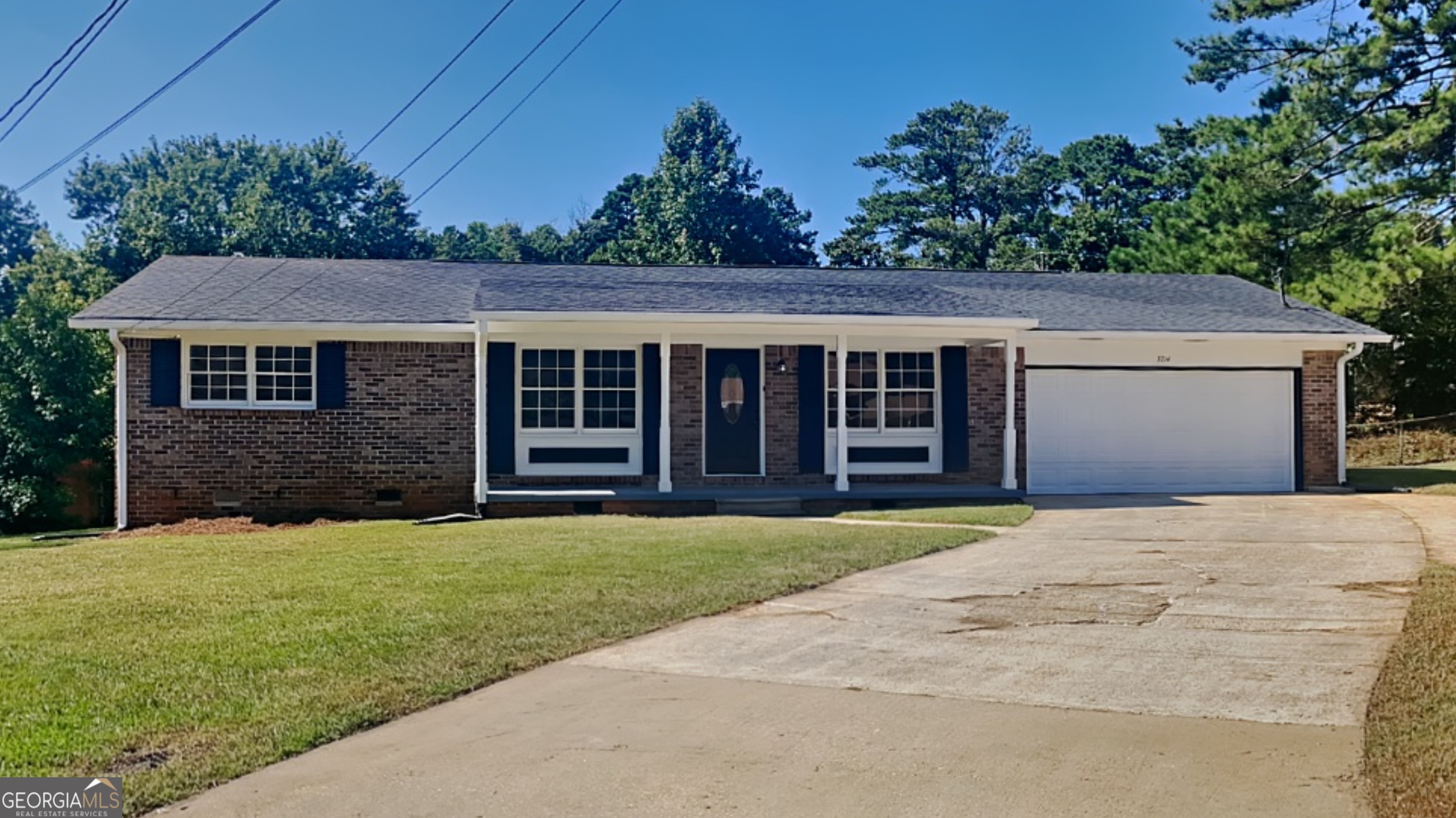 a view of a house with a yard and potted plants