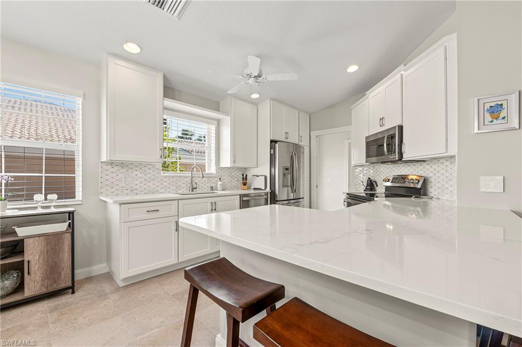 a large kitchen with kitchen island a sink appliances and cabinets