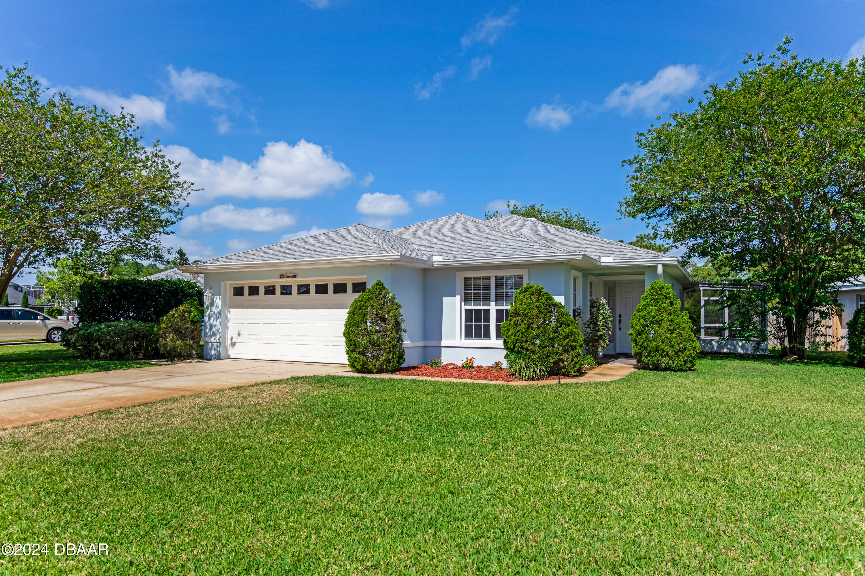 a front view of a house with a yard and trees