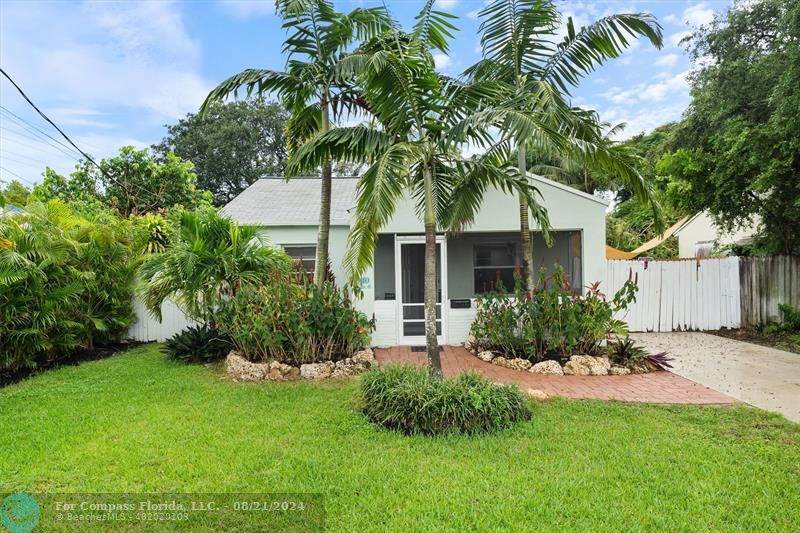 a front view of a house with a garden and yard