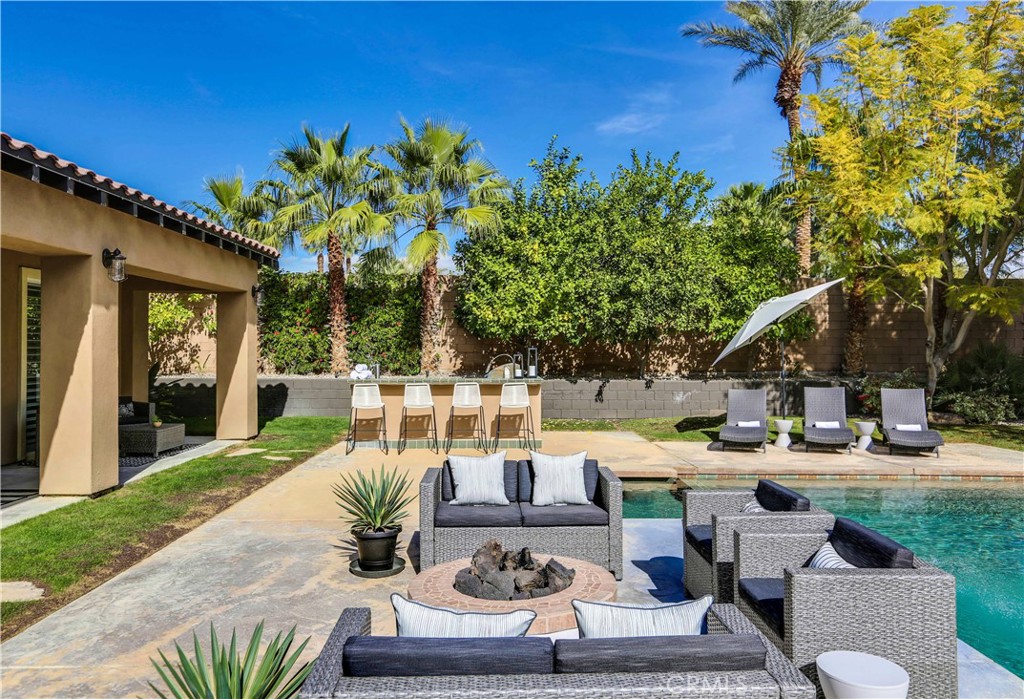 a view of a patio with couches table and chairs and potted plants