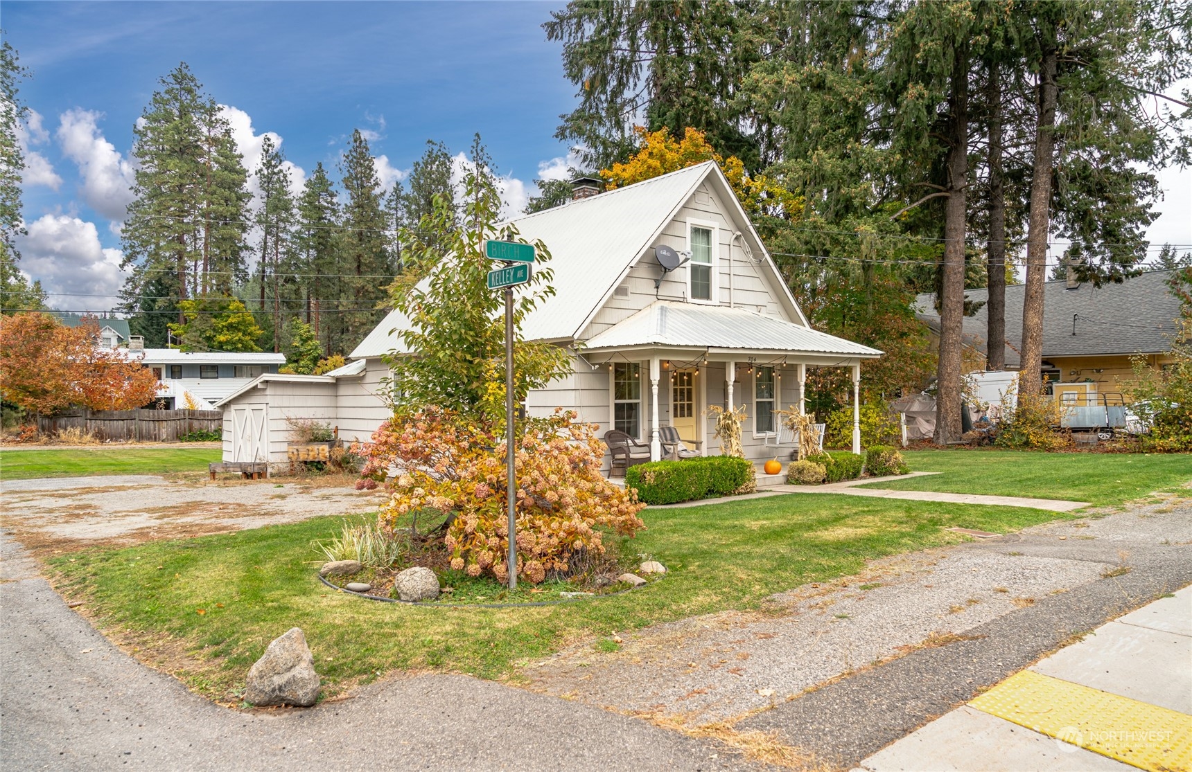 a front view of a house with a garden and trees