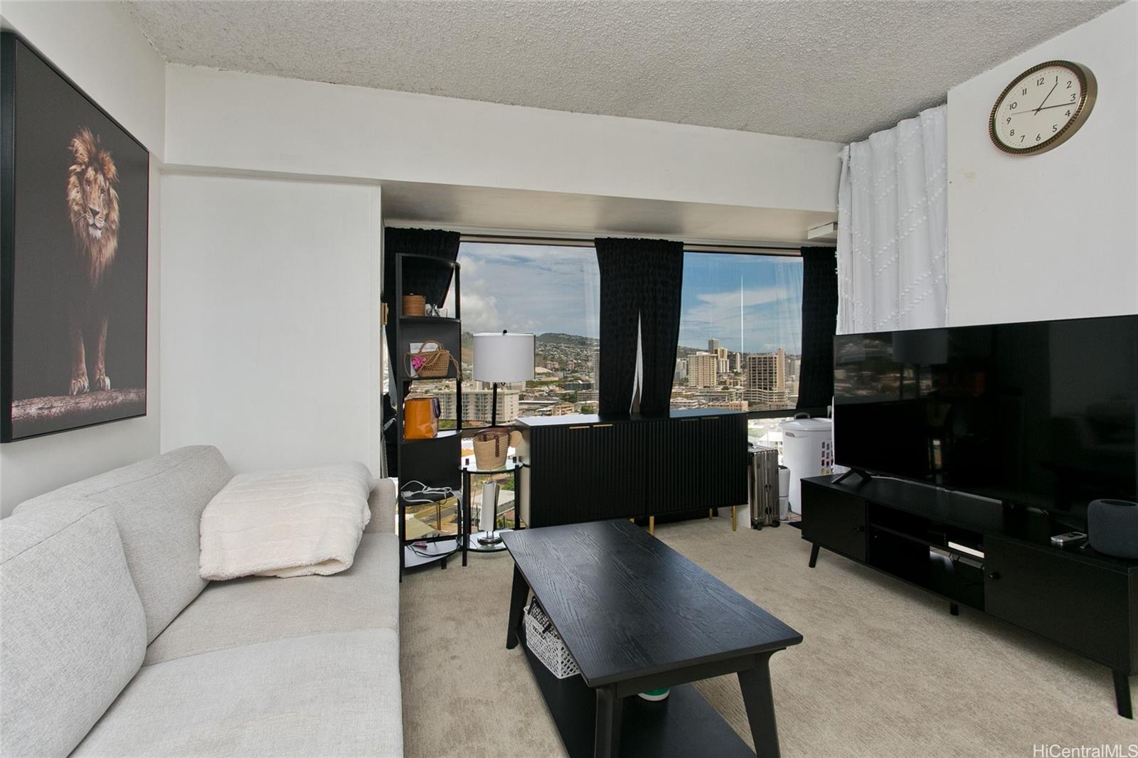 a living room with furniture a window and a flat screen tv