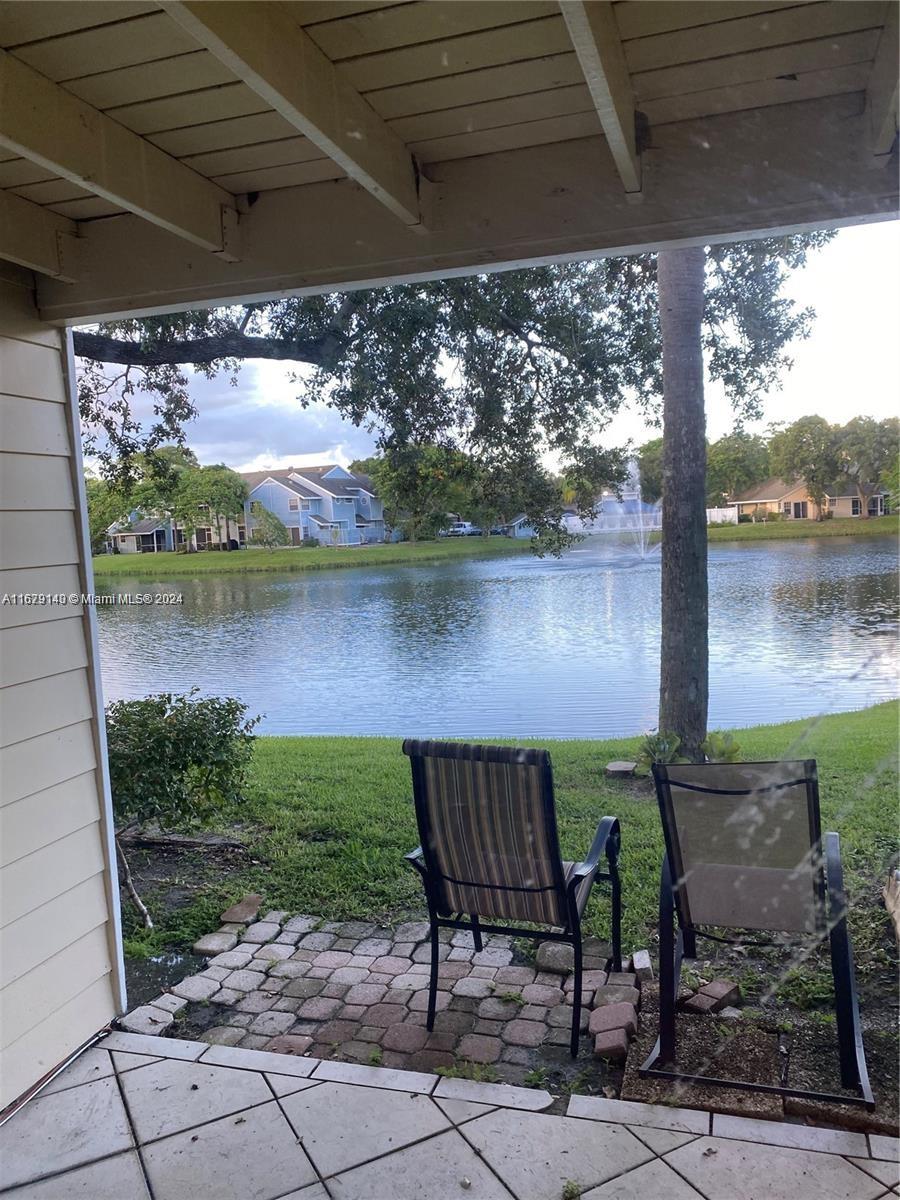 a view of a chairs and table in patio with a lake view