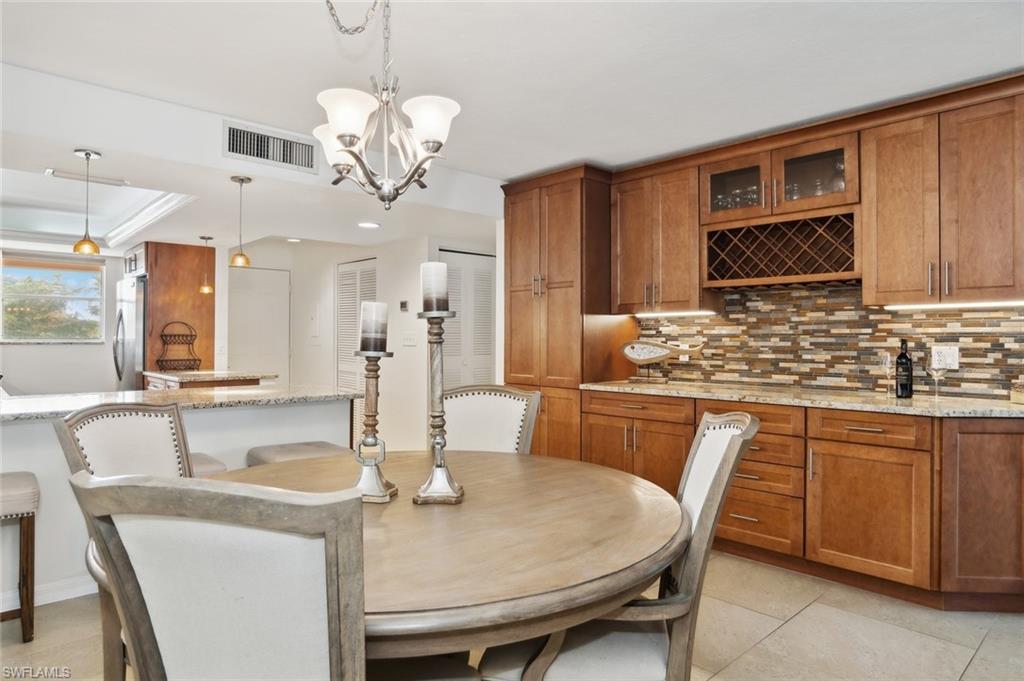 Dining room featuring ornamental molding, light tile patterned floors, and a chandelier