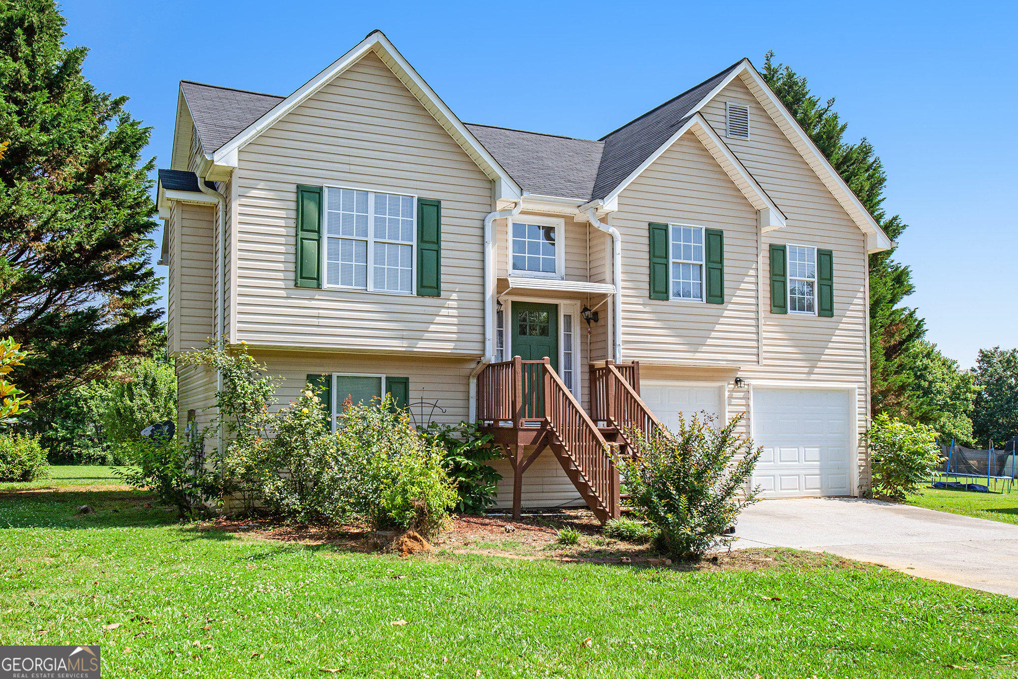 a front view of a house with a yard and plants