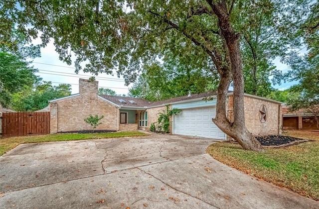 a view of a house with a yard and large tree