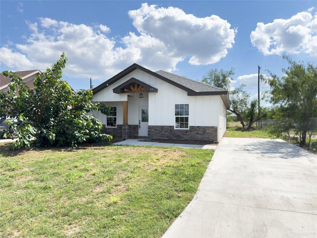 a front view of house with yard and trees around