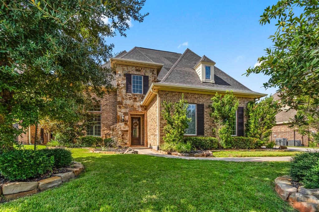 a front view of a house with a yard and fountain