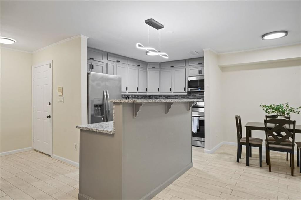 a kitchen with kitchen island a dining table chairs appliances and cabinets