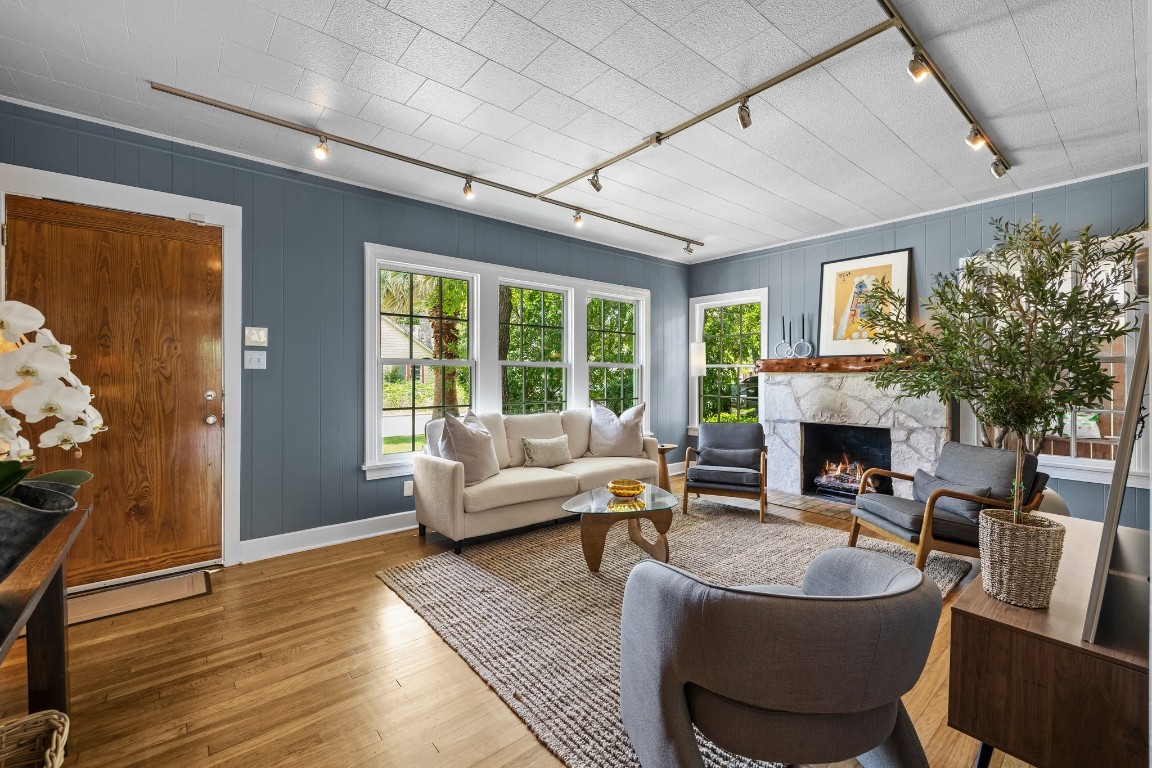 a living room with fireplace furniture and a large window