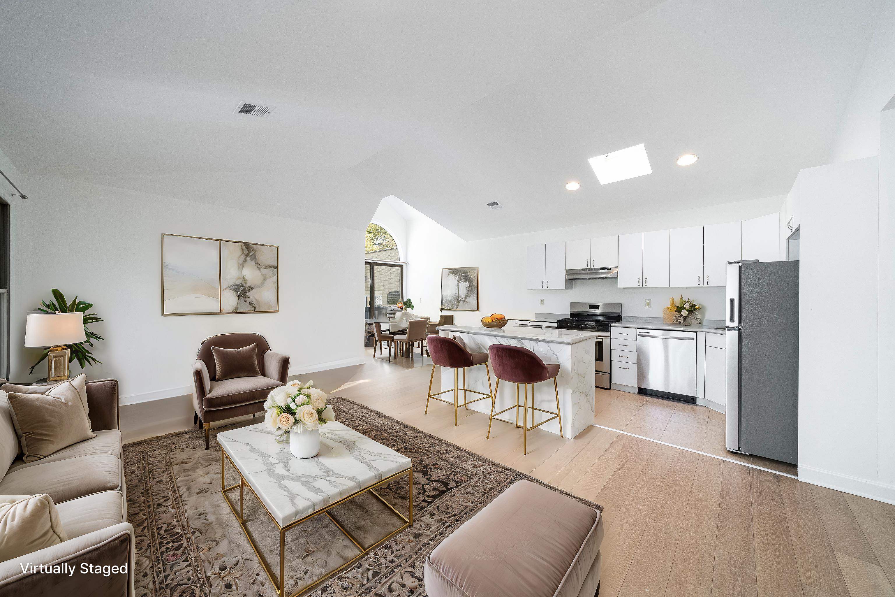 a living room with furniture and a view of kitchen