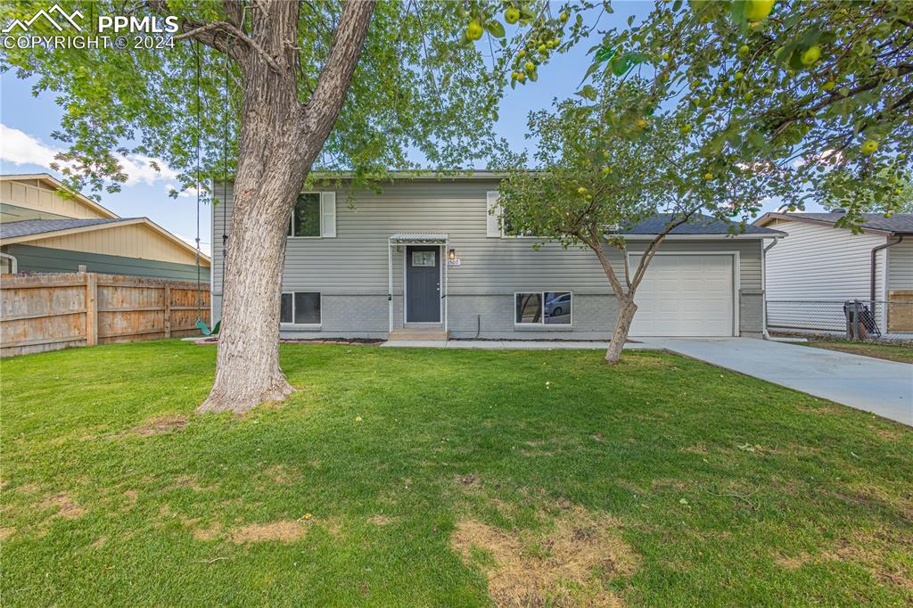 View of front of house featuring a garage and a front lawn