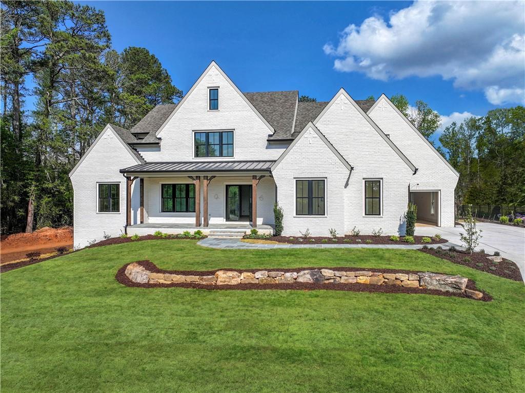 a front view of a house with a garden and porch