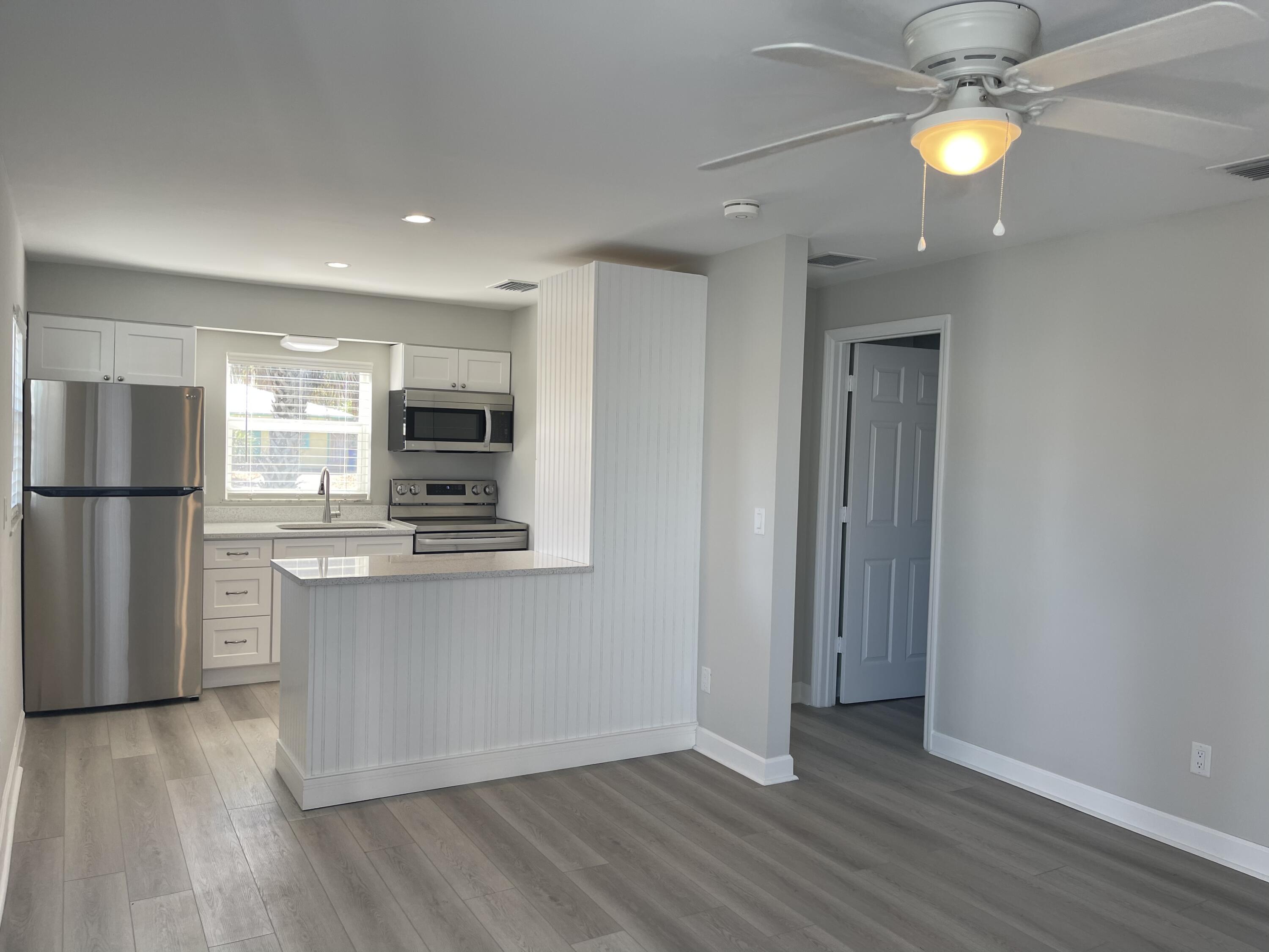 a view of kitchen with stainless steel appliances granite countertop cabinets and wooden floor