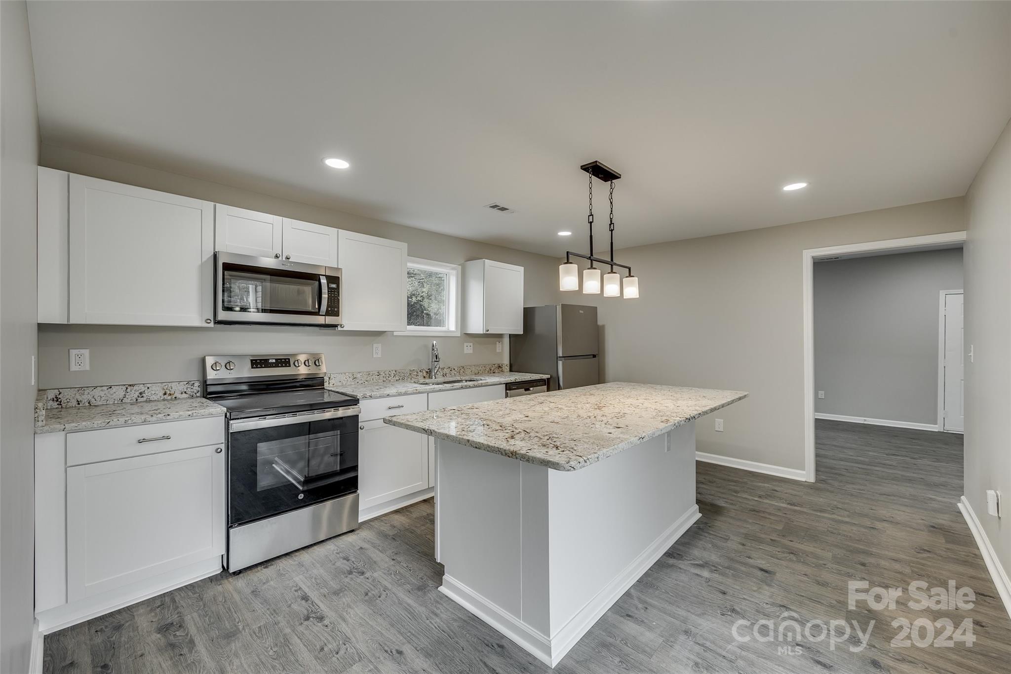 a kitchen with stainless steel appliances granite countertop a sink stove and microwave