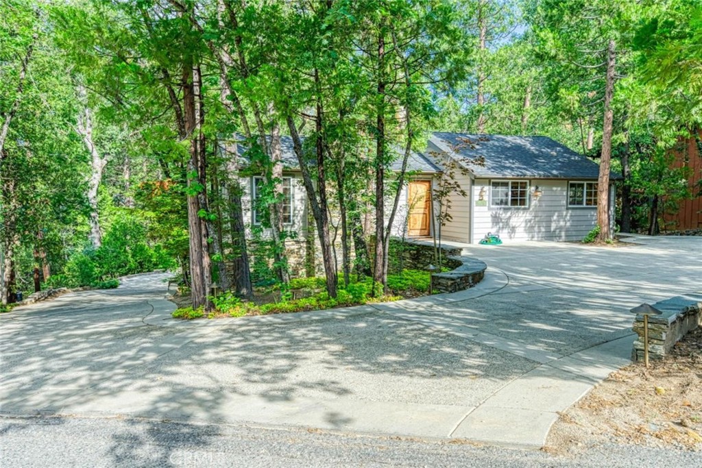 a front view of a house with a yard and trees