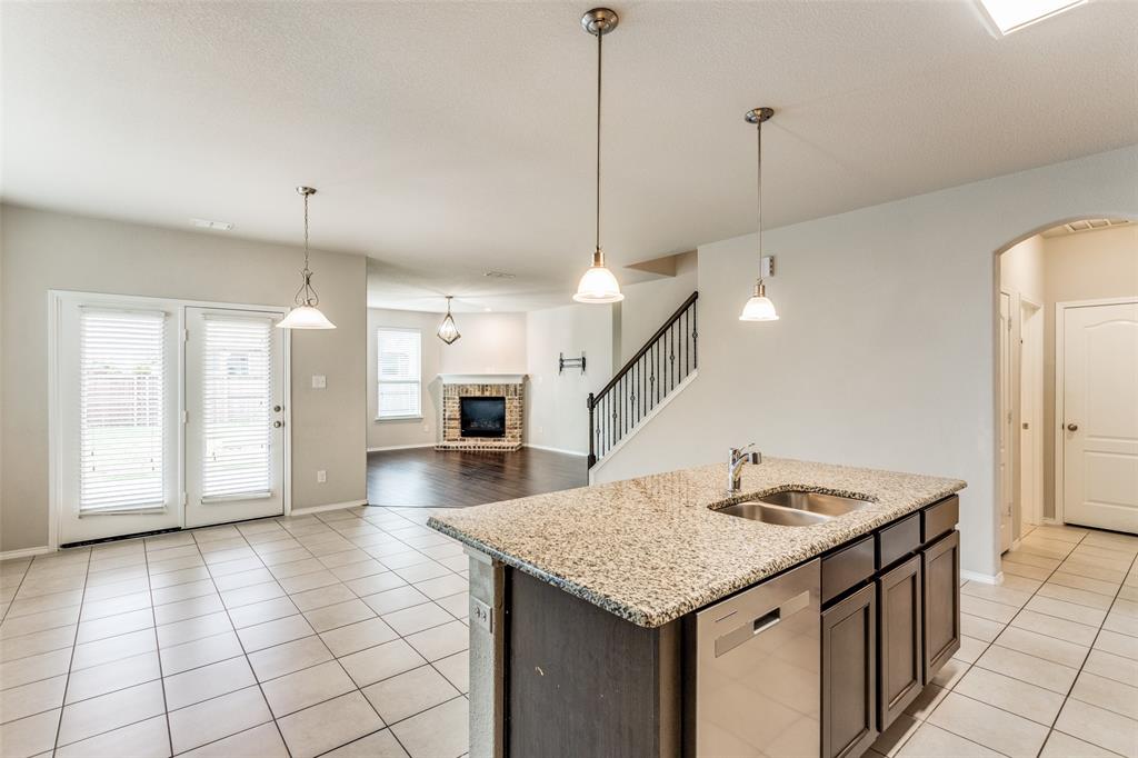 a kitchen with granite countertop a sink a counter space and stainless steel appliances