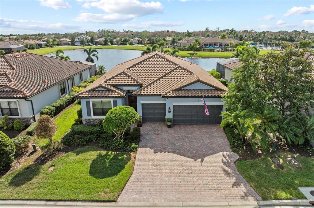 an aerial view of a house with a yard and lake view