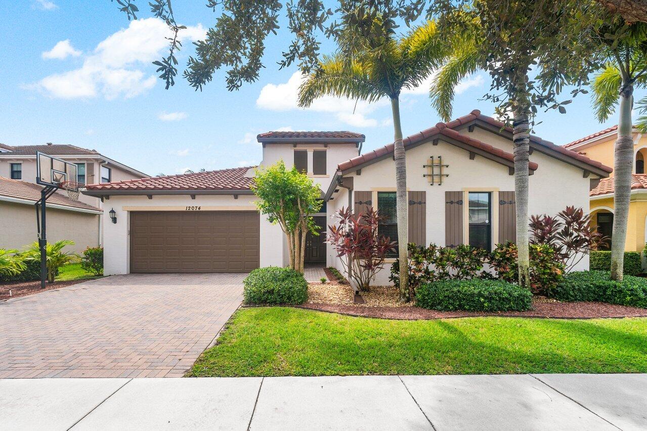 a front view of a house with a garden and palm trees