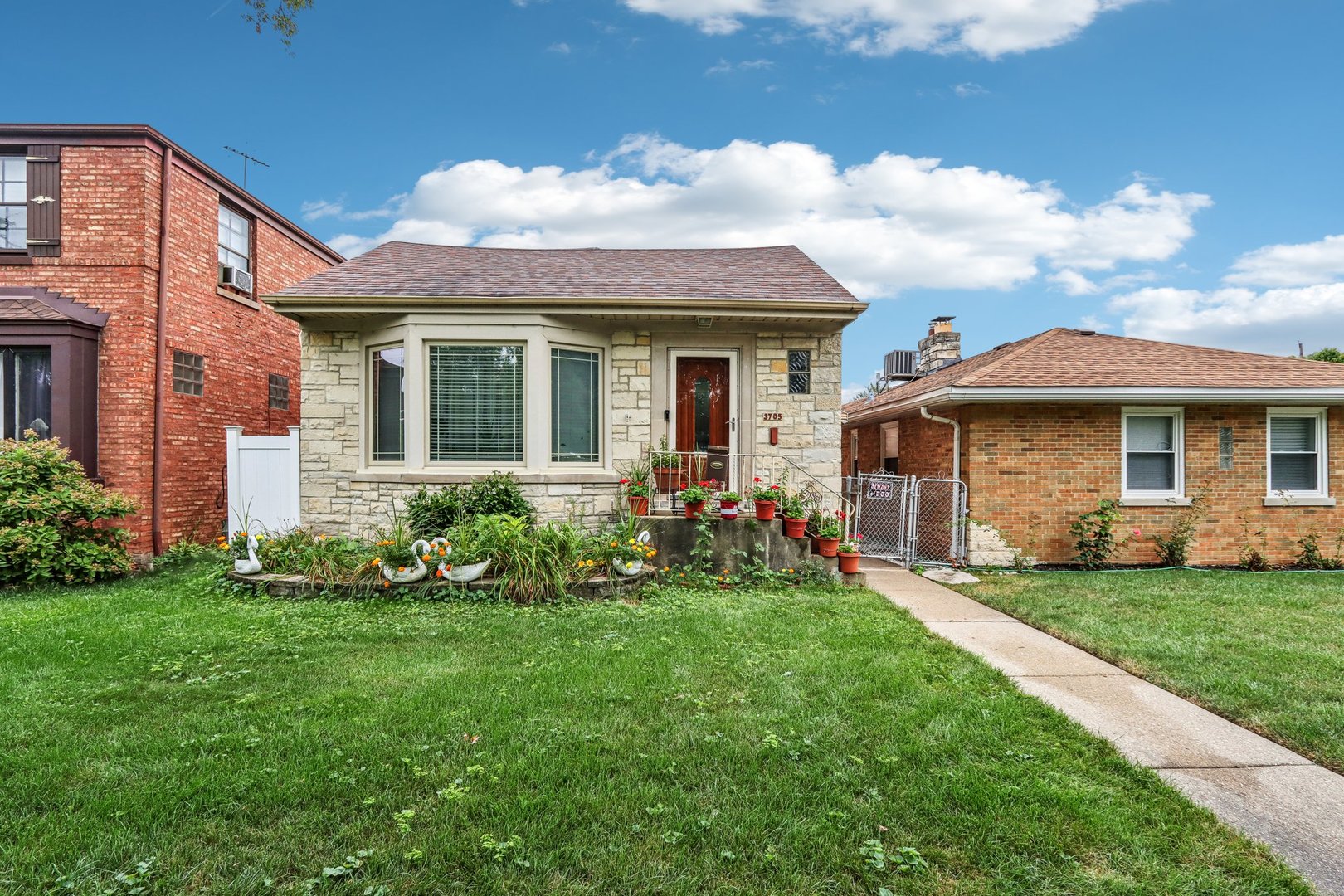 a front view of a house with a garden and plants