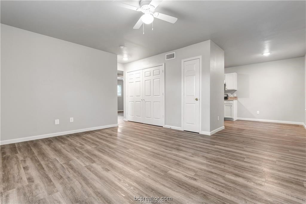 a view of an empty room with wooden floor